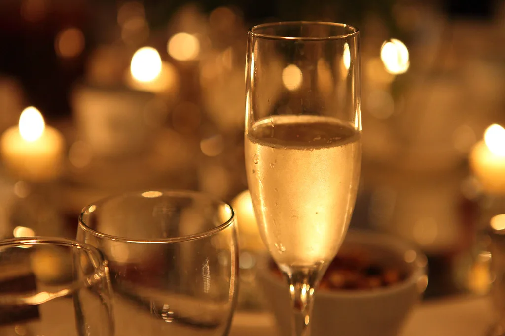Flûte de champagne sur une table de réception éclairée à la bougie